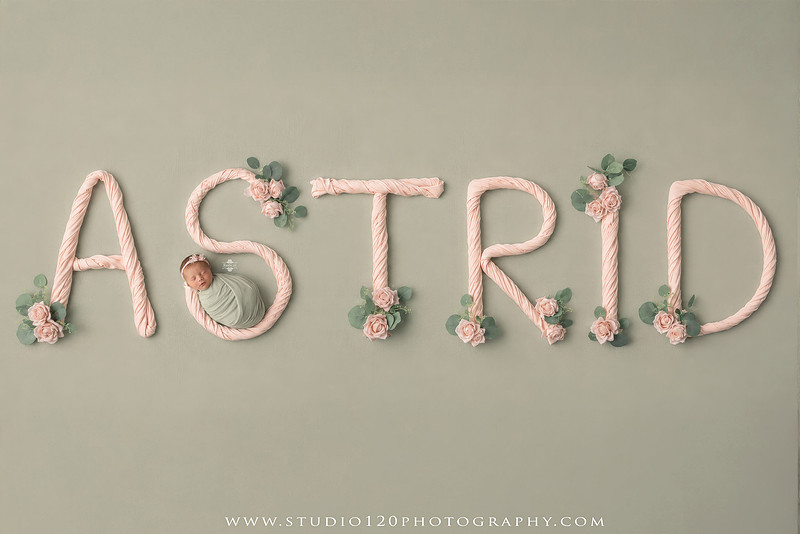 Professional newborn photography session featuring baby girl Astrid with custom Ramona Bulldogs football-themed portraits, a handcrafted Bulldogs newborn bucket wrap, football helmet and football, soft neutral newborn poses, vintage wooden bed with floral styling, plush bunny, blush and cream wraps, personalized 3D printed name sign, custom ASTRID letter artwork, and timeless studio newborn portraits by Studio 120 Photography in Ramona, CA.