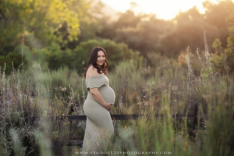 A golden hour maternity photography session at Lake Poway featuring an expecting family surrounded by wildflowers, rolling hills, and mountain views. The gallery includes romantic portraits of the parents, family photos with their young son, candid moments celebrating a growing family, and close-up images highlighting the mother's baby bump and the excitement of becoming a big brother. Captured in soft natural light with timeless neutral tones by Studio 120 Photography in Ramona, serving families throughout San Diego.