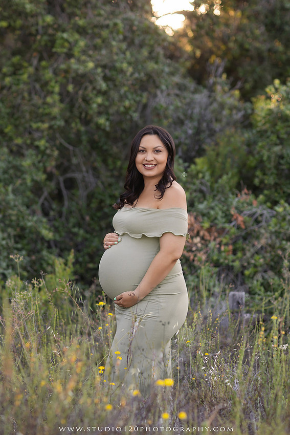 A golden hour maternity photography session at Lake Poway featuring an expecting family surrounded by wildflowers, rolling hills, and mountain views. The gallery includes romantic portraits of the parents, family photos with their young son, candid moments celebrating a growing family, and close-up images highlighting the mother's baby bump and the excitement of becoming a big brother. Captured in soft natural light with timeless neutral tones by Studio 120 Photography in Ramona, serving families throughout San Diego.