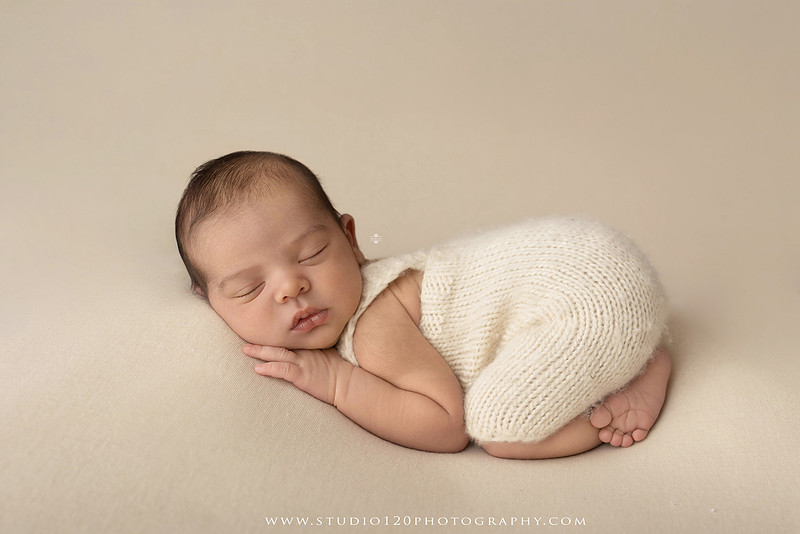 A professional newborn photography gallery featuring baby Caleb with his family at Studio 120 Photography in Ramona. The collection includes timeless family portraits with parents and four siblings, heartfelt individual parent and baby portraits, sibling photos gathered around a miniature crib, classic wrapped newborn poses, a personalized knit nightcap embroidered with Caleb's name, a custom football-themed newborn setup on a football under stadium lights, a football bowl prop with vintage football décor, and an organic newborn portrait with rich green knit textures and natural greenery. Soft neutral tones, personalized details, and family-centered images celebrate the arrival of a new baby while serving families throughout Ramona and the San Diego area.