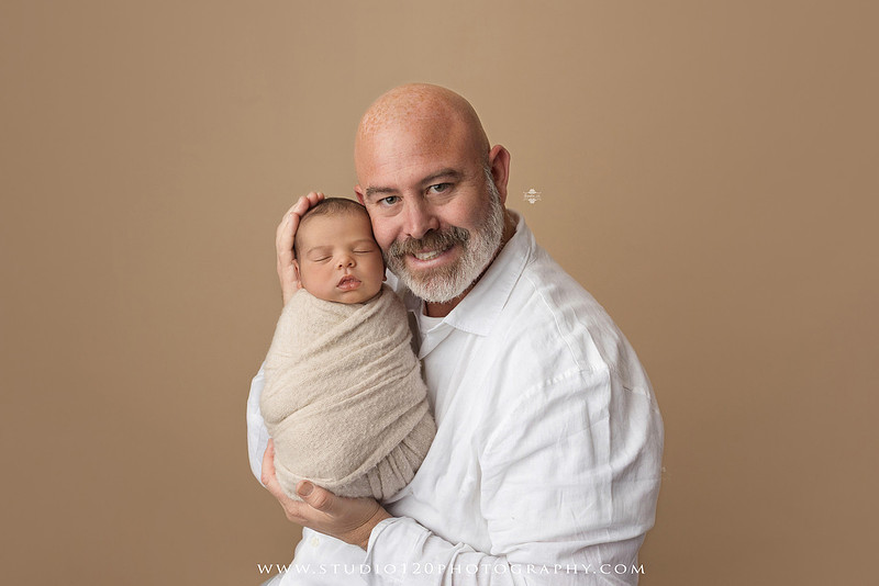 A professional newborn photography gallery featuring baby Caleb with his family at Studio 120 Photography in Ramona. The collection includes timeless family portraits with parents and four siblings, heartfelt individual parent and baby portraits, sibling photos gathered around a miniature crib, classic wrapped newborn poses, a personalized knit nightcap embroidered with Caleb's name, a custom football-themed newborn setup on a football under stadium lights, a football bowl prop with vintage football décor, and an organic newborn portrait with rich green knit textures and natural greenery. Soft neutral tones, personalized details, and family-centered images celebrate the arrival of a new baby while serving families throughout Ramona and the San Diego area.