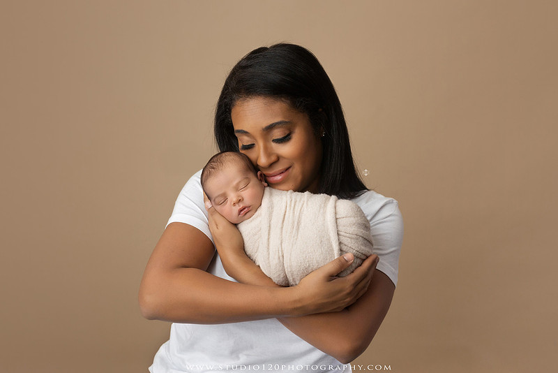 A professional newborn photography gallery featuring baby Caleb with his family at Studio 120 Photography in Ramona. The collection includes timeless family portraits with parents and four siblings, heartfelt individual parent and baby portraits, sibling photos gathered around a miniature crib, classic wrapped newborn poses, a personalized knit nightcap embroidered with Caleb's name, a custom football-themed newborn setup on a football under stadium lights, a football bowl prop with vintage football décor, and an organic newborn portrait with rich green knit textures and natural greenery. Soft neutral tones, personalized details, and family-centered images celebrate the arrival of a new baby while serving families throughout Ramona and the San Diego area.