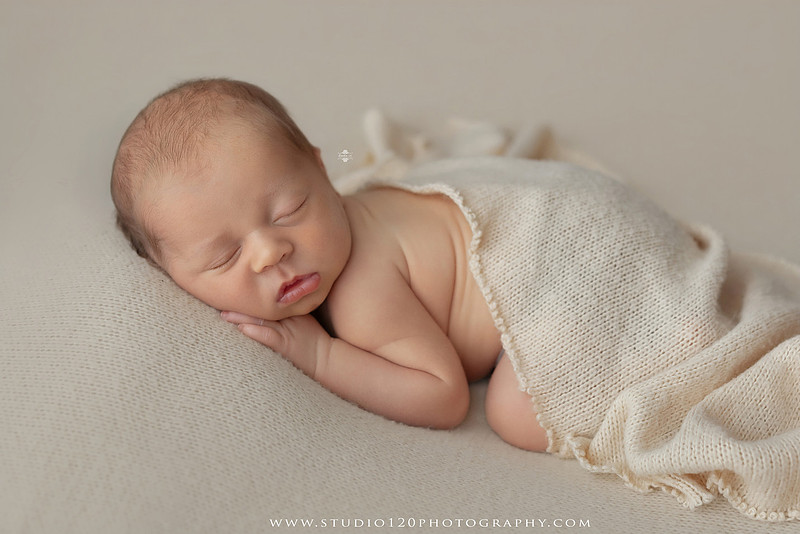 A collection of timeless newborn portraits featuring a sleeping baby boy photographed in Studio 120 Photography's Ramona studio. The gallery includes organic, neutral styling with soft cream wraps, textured knit blankets, rustic wooden bowls, vintage wash tubs, woven baskets, a modern macramé hammock, and a miniature woodland chair surrounded by handcrafted pine trees. Rich wood tones, eucalyptus greenery, dried botanicals, and warm natural textures create an elegant, earthy aesthetic. The collection also features simple beanbag portraits highlighting the baby's tiny features, peaceful sleeping poses, sweet smiles, and bright awake expressions. These fine art newborn photographs capture the beauty of a baby's earliest days with classic, heirloom-quality styling for families throughout Ramona, San Diego, Poway, Escondido, Lakeside, El Cajon, and surrounding Southern California communities.
