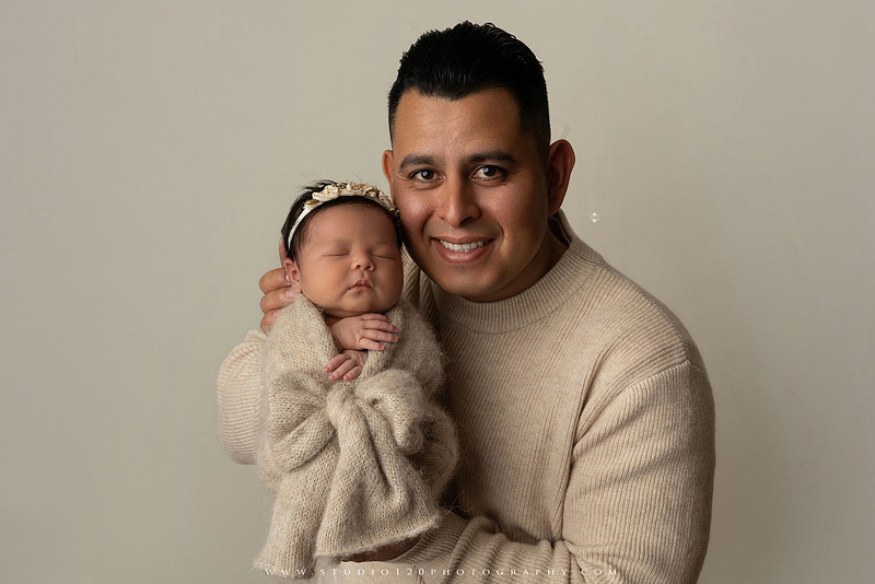 Timeless family newborn portraits featuring parents, siblings, and their new baby girl in soft neutral tones. The gallery includes standing family portraits, overhead sibling and newborn portraits, and natural moments celebrating the love, connection, and joy of welcoming a new baby. Captured at Studio 120 Photography in Ramona, serving San Diego County.