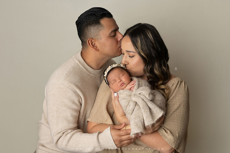 Timeless family newborn portraits featuring parents, siblings, and their new baby girl in soft neutral tones. The gallery includes standing family portraits, overhead sibling and newborn portraits, and natural moments celebrating the love, connection, and joy of welcoming a new baby. Captured at Studio 120 Photography in Ramona, serving San Diego County.
