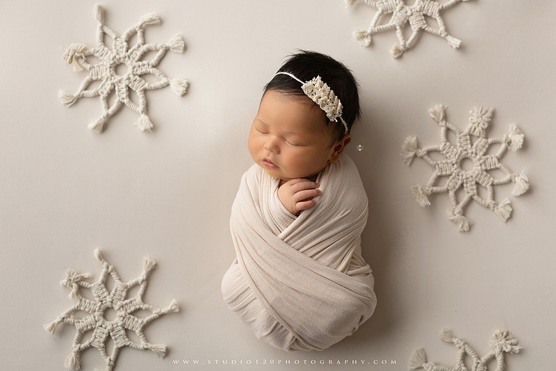 A collection of newborn baby girl portraits featuring peaceful sleeping poses, soft neutral wraps, delicate floral headbands, textured blankets, rustic baskets, natural wood props, creamy backdrops, and a special police tribute setup with a badge and Thin Blue Line flag. The gallery showcases timeless, baby-led newborn photography with warm, organic tones at Studio 120 Photography in Ramona, serving San Diego County.