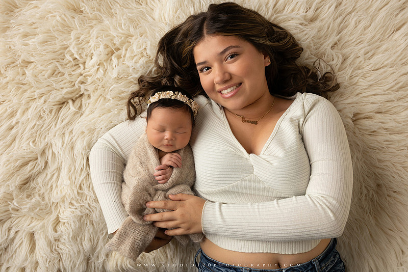 Timeless family newborn portraits featuring parents, siblings, and their new baby girl in soft neutral tones. The gallery includes standing family portraits, overhead sibling and newborn portraits, and natural moments celebrating the love, connection, and joy of welcoming a new baby. Captured at Studio 120 Photography in Ramona, serving San Diego County.