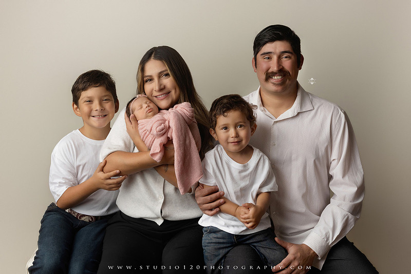 Newborn baby girl photography session featuring soft pink, lavender, blue and neutral styling, floral newborn portraits, rustic western-inspired setups, sibling photos with two big brothers, and family portraits with parents at Studio 120 Photography in Ramona, California.