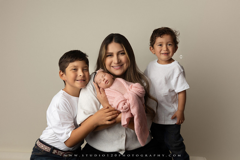 Newborn baby girl photography session featuring soft pink, lavender, blue and neutral styling, floral newborn portraits, rustic western-inspired setups, sibling photos with two big brothers, and family portraits with parents at Studio 120 Photography in Ramona, California.